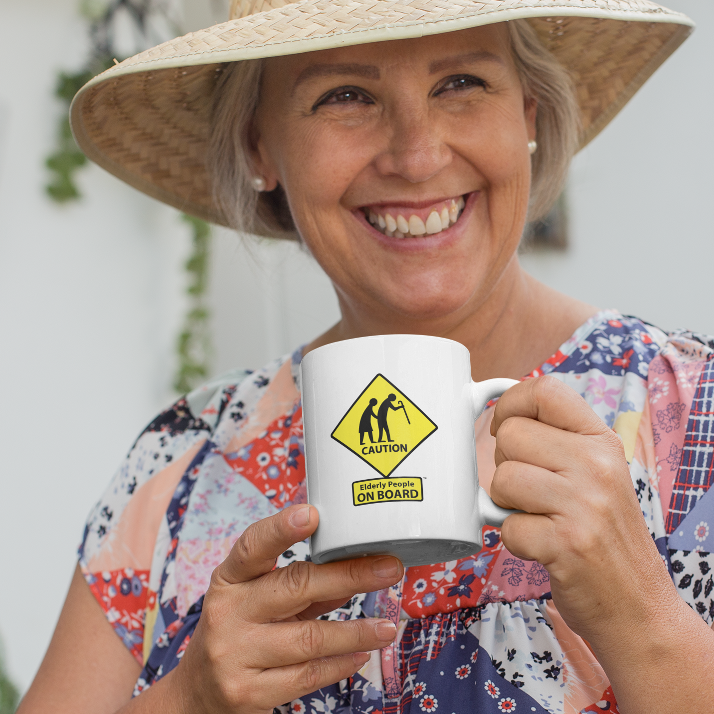 Mature woman holding a coffee mug that says "Caution: Elderly People ON BOARD"